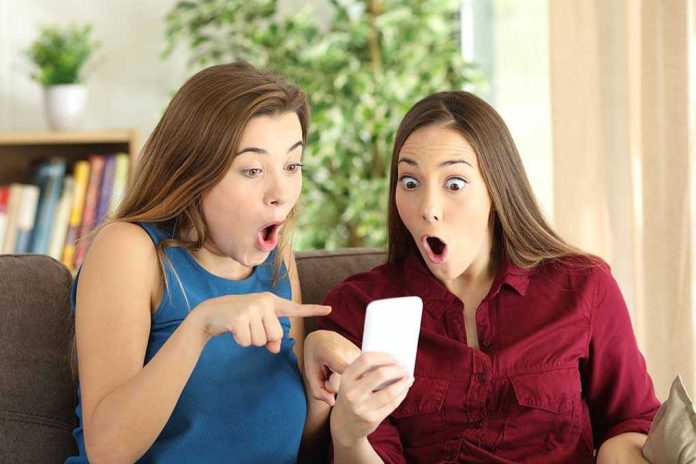 516056992 Two women look surprised at a phone