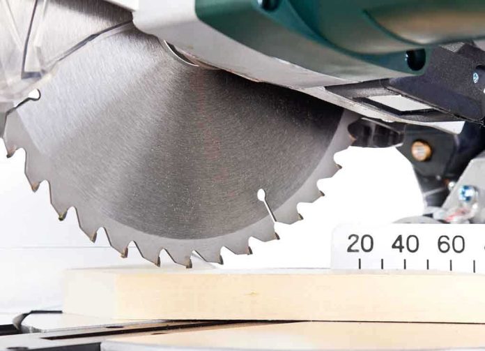 Close up of a circular saw blade cutting through a piece of wood