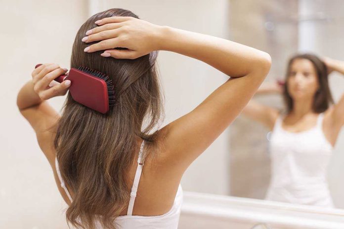 A woman brushing her long hair in front of a bathroom mirror