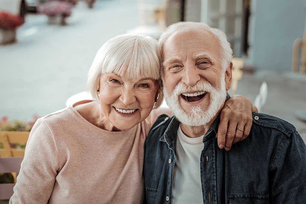 Elderly couple smiling together outdoors