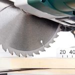 Close up of a circular saw blade cutting through a piece of wood