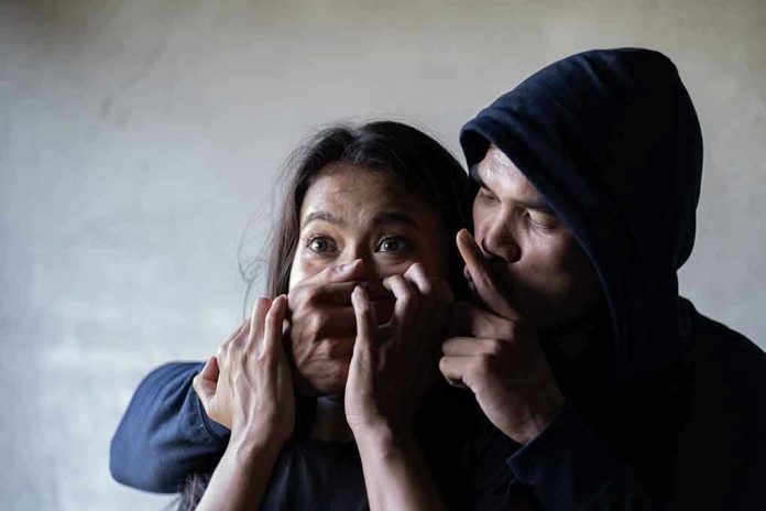 Man holding womans mouth gesturing silence