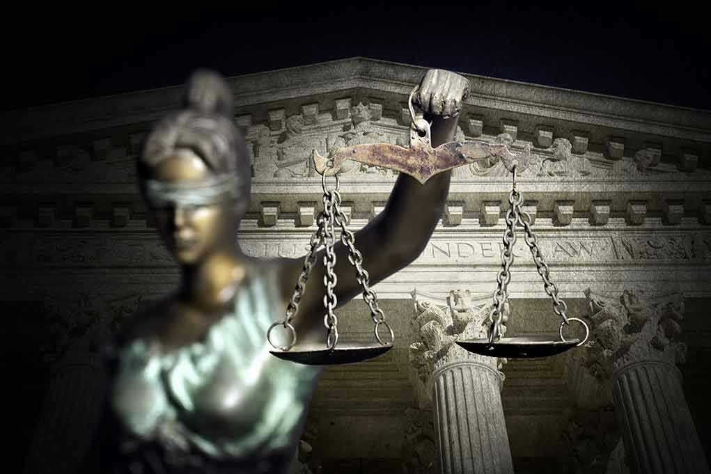 Blindfolded Lady Justice with scales Supreme Court background
