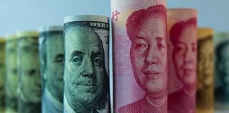 Rolled US dollar and Chinese yuan banknotes.