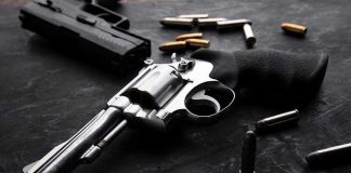 Revolvers and bullets on a dark surface.