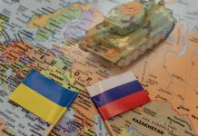 Shockwaves as U.S. Considers Russian Land Grab Toy tank on map with Ukraine and Russia flags.