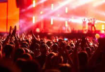 Hip-Hop Influencer’s SHOCKING Predator Scheme Exposed Crowd at concert with vibrant stage lights.