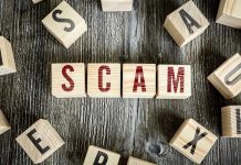 Robocall Scheme Targets Thousands—No Jail Time! Wooden blocks spell SCAM on a rustic surface.