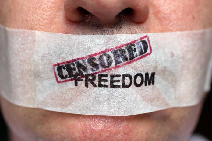 Close-up of a persons mouth covered with tape that reads CENSORED FREEDOM