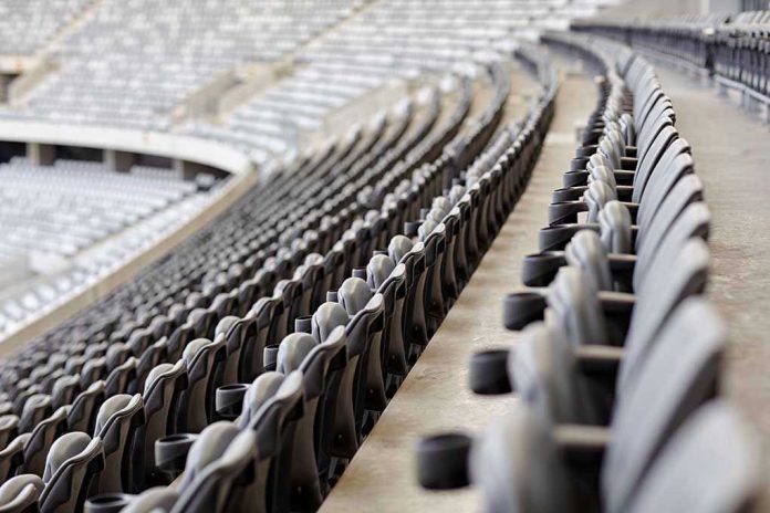 Empty rows of gray seats in a stadium.