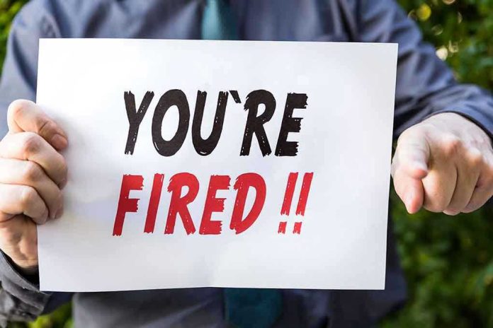 Person holding YOURE FIRED sign.