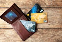 Wallet with three credit cards on wooden surface
