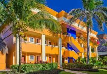 Colorful resort building surrounded by palm trees and lush greenery