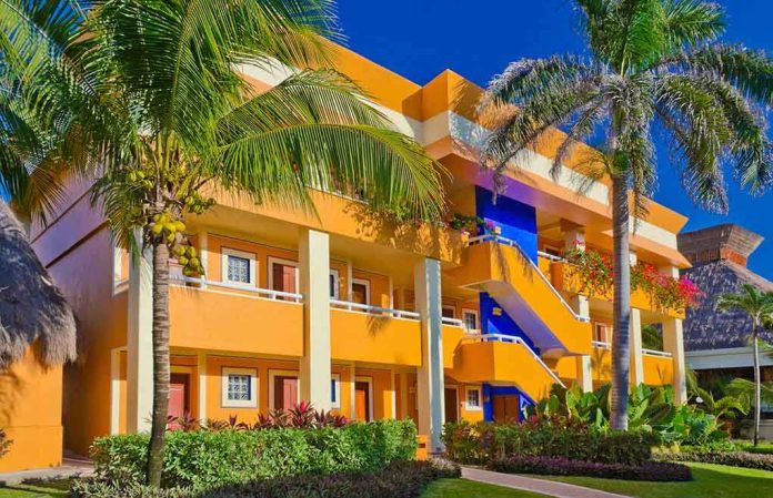 shutterstock_140180596.jpg Colorful resort building surrounded by palm trees and lush greenery