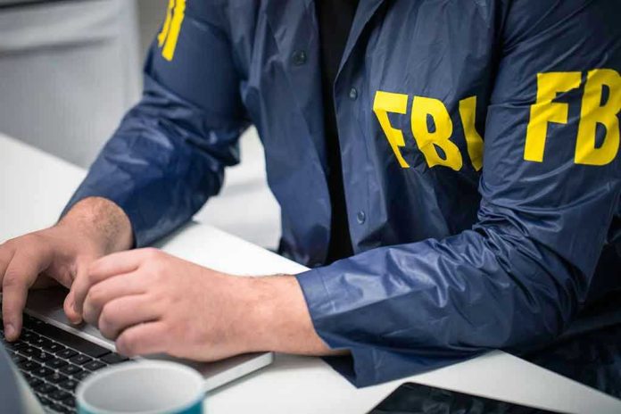 629482379 Person in FBI jacket typing on a laptop.