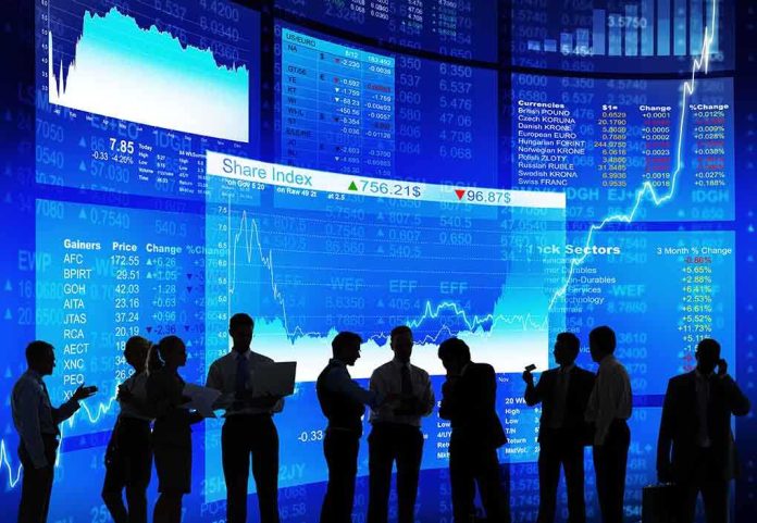 shutterstock_178709456.jpg Silhouetted business professionals in front of digital stock market displays