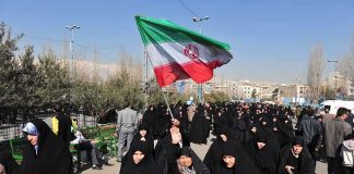 Human Children Shields Order Shocks Tehran Group of women in black attire marching with an Iranian flag