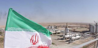 Iranian flag near an industrial gas refinery.