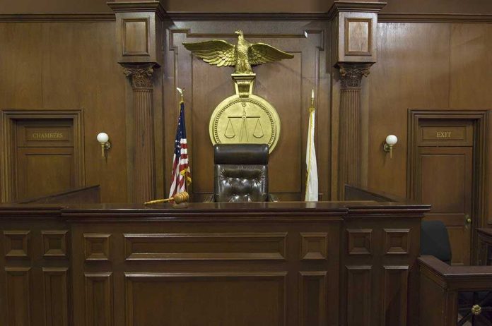 Interior of a courtroom featuring a judges bench and American flag