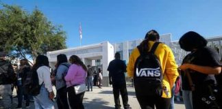 Students standing outside a high school entrance