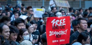Free Speech Recast as Sedition protest crowd holding a red sign