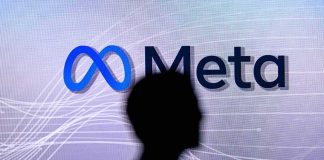 silhouette in front of Meta logo on screen