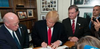 Power Surge: Orders Fly, Details Don’t man in suit signing a document at a counter