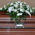 Coffin with white floral arrangement