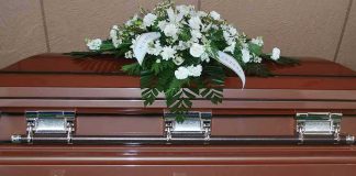 Coffin with white floral arrangement