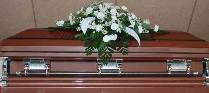 shutterstock_384042715 Coffin with white floral arrangement