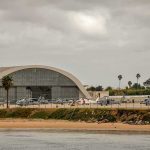 airport hangar with helicopters near a shoreline