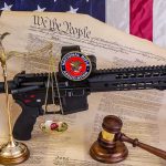 Rifle with NRA badge on Constitution backdrop with scales and gavel