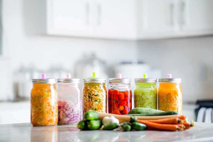 Assorted pickled vegetables in jars on a kitchen counter