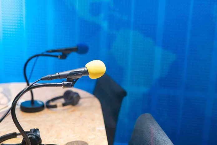 shutterstock_1562732692 Podcast studio microphones on a desk