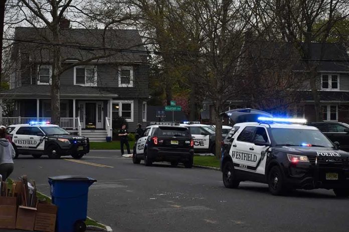 Police SUVs with lights on block a suburban street