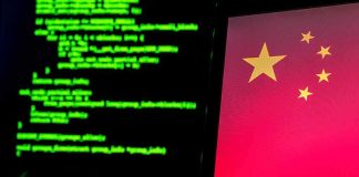 Laptop screen with Chinese flag beside green computer code