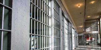 Prison cell block with metal bars and corridor