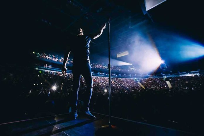 shutterstock_568524262 Singer on stage facing a large concert crowd
