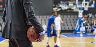 Legend Falls At 90 – Cause Undisclosed Basketball coach in suit holding ball courtside