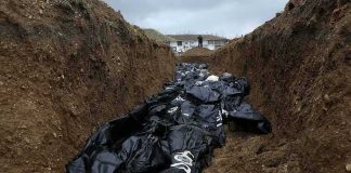 Body bags in a mass grave trench