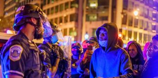 Protesters talk with police officers at night in city street