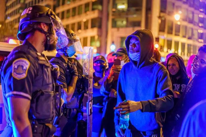 Protesters talk with police officers at night in city street