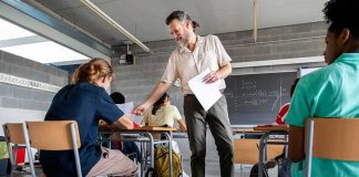 Teacher handing out papers in a classroom