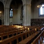Rows of wooden chairs inside a Gothic church nave