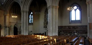 Rows of wooden chairs inside a Gothic church nave